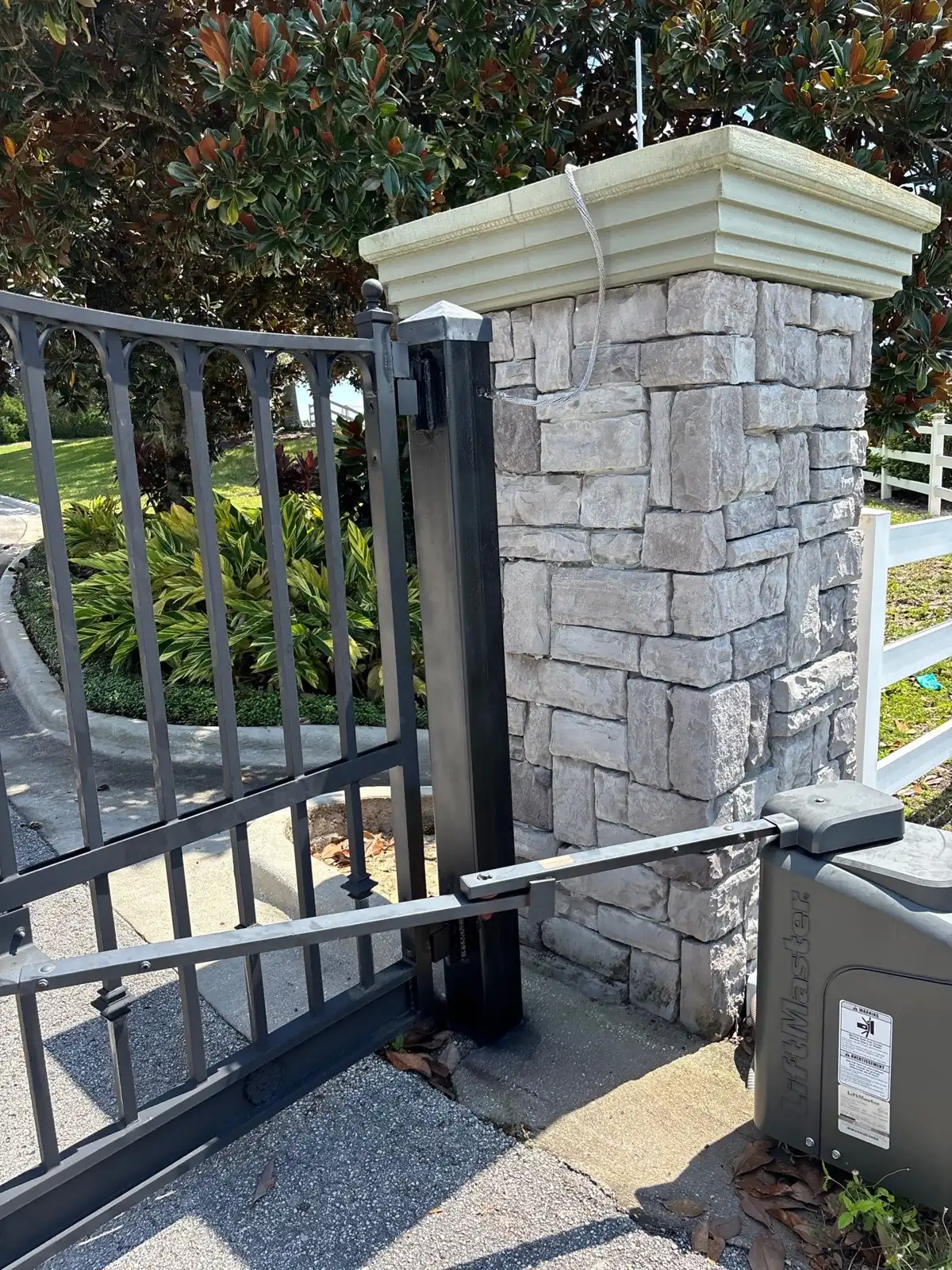 Swing gate operator arm mounted on a stone pillar in Groveland, FL